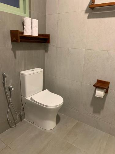een badkamer met een wit toilet in een kamer bij Villa beachcomber in Ambalangoda