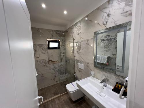 a bathroom with a sink and a mirror at Hotel Tramonto Vlore in Vlorë