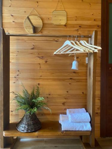 uma parede de madeira com toalhas e uma planta numa prateleira em Agora Farmhouse em Koman