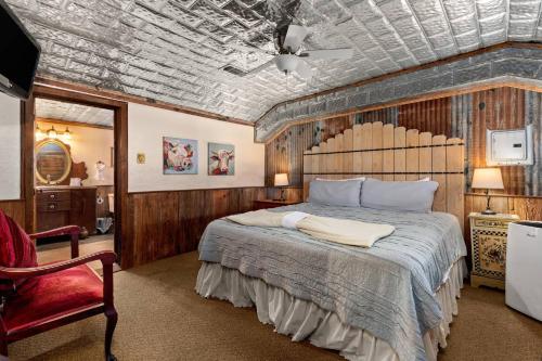a bedroom with a large bed and a red chair at #6 The Root Cellar in New Braunfels