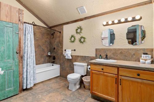 a bathroom with a toilet and a sink and a tub at #5 The Dog Run Suite in New Braunfels