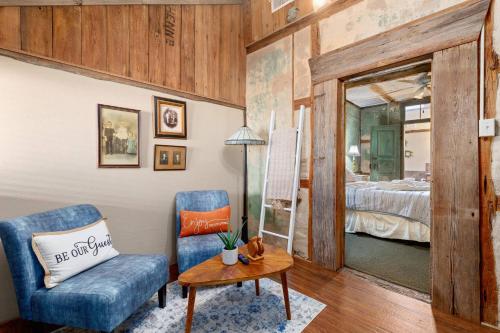a room with a blue chair and a table and a bed at #5 The Dog Run Suite in New Braunfels