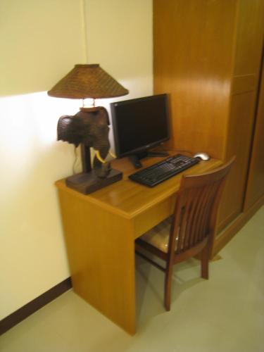 a desk with a computer and a lamp on it at Rafael Hotel and Mansion Bangkok in Lat Krabang