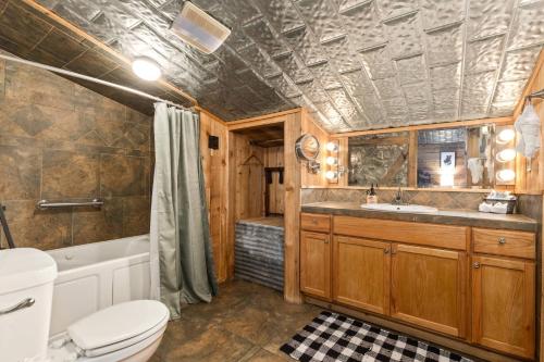a bathroom with a toilet and a tub and a sink at #8 The Cabin in New Braunfels