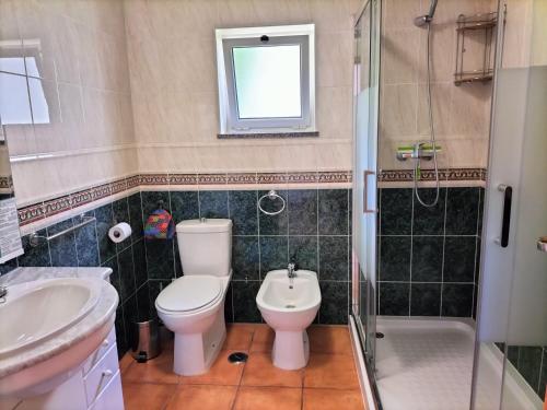 a bathroom with a toilet and a sink and a shower at Vila Mós in Lagos