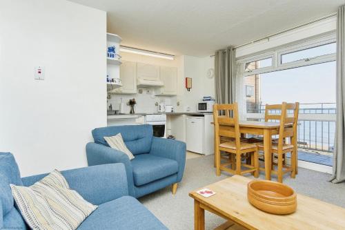 ein Wohnzimmer mit einem blauen Sofa und einem Tisch in der Unterkunft Shanklin Beach - Napier in Shanklin