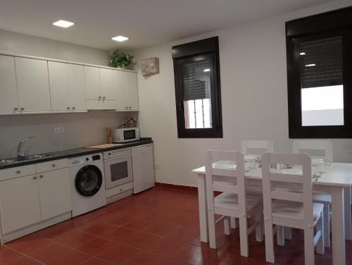 a kitchen with a table and chairs and a washing machine at Apartamentos La Piedra de Nájera in Nájera