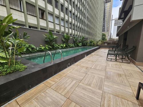 uma piscina ao lado de um edifício em Pamplona Studios by Housi em São Paulo
