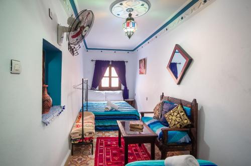 a bedroom with a bed and a table and a window at Dar Chourafa Riad in Chefchaouen