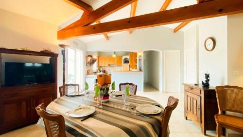 une salle à manger avec une table et des chaises et une cuisine dans l'établissement Jolie villa proche des commerces, pistes cyclables, à Sainte-Marie de Ré