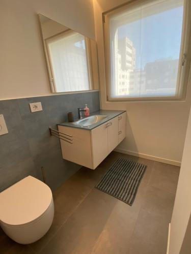 ein Bad mit einem WC, einem Waschbecken und einem Fenster in der Unterkunft HZ+ Costantini in Pordenone