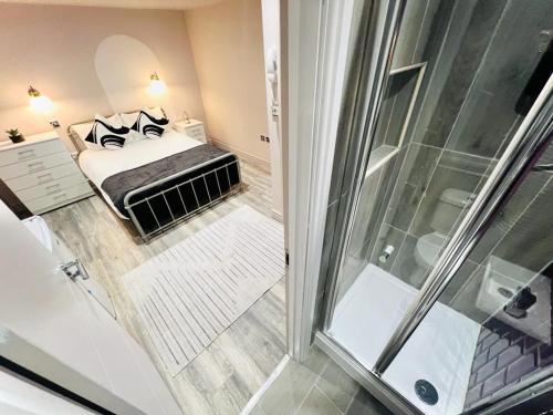 ロンドンにあるCentral studios: Exceptional standard for a memorable stayのベッド1台とシャワー付きの小さな客室です。