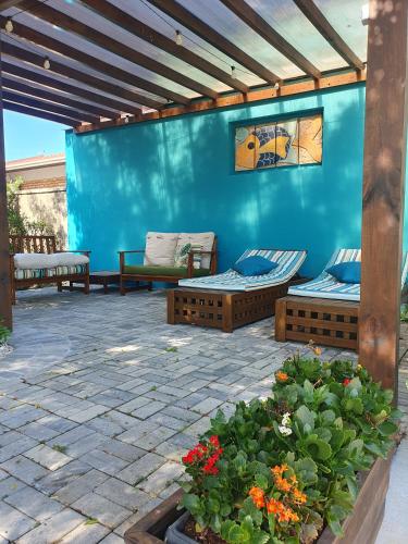 a patio with two beds and a blue wall at Vila Alegria in Bombinhas