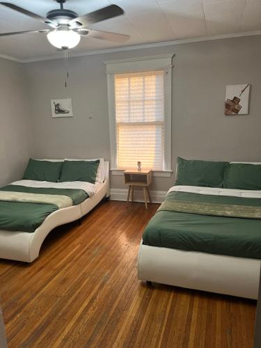 Habitación con 2 camas y ventana en Cozy Home Away From Home 3 bedrooms 5 beds 1 bath en Rochester
