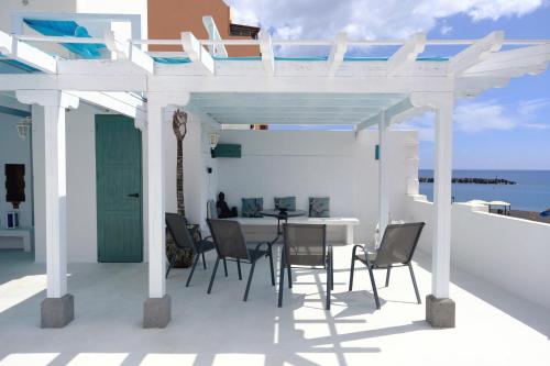 - un patio blanc avec une table et des chaises dans l'établissement Rooftop Dreamhouse - 3BR with Seaviews, à Santa Cruz de la Palma