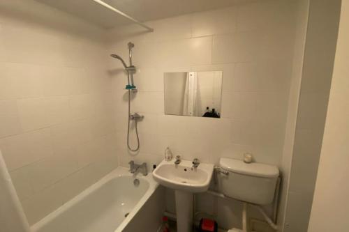 a bathroom with a sink and a toilet and a tub at MODERN 1 Bedroom Ground Floor Flat in London