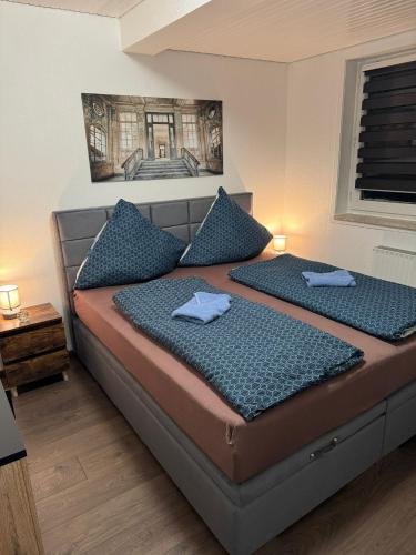 a bedroom with a large bed with blue pillows at Blue Wave in Bad Harzburg