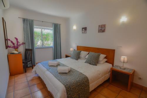 a bedroom with a large bed and a window at Vila Mós in Lagos