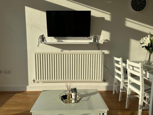 a living room with a radiator and a tv on a wall at Luxury 1 Bedroom Apartment - City Centre - Balcony - Near O2 Academy in Birmingham