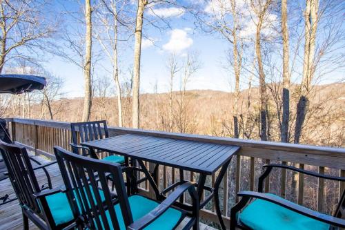 a table and chairs on a deck with a view at Little Elk Lodge in Elk Park