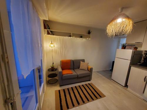 un salon avec un canapé et une cuisine dans l'établissement Appartement cosy proche mer, à Les Sables-dʼOlonne