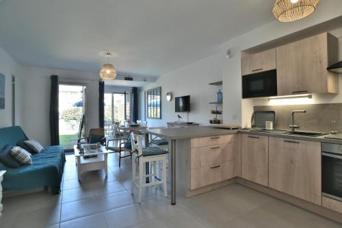 une cuisine avec des placards en bois et un canapé bleu dans l'établissement Les Flots de Port Mer Maison tout confort pour 4 pers avec jardinet à Port Mer à Cancale à 5 min à pied de la plage Côte d'Emeraude, Ille et Vilaine, Bretagne, à Cancale