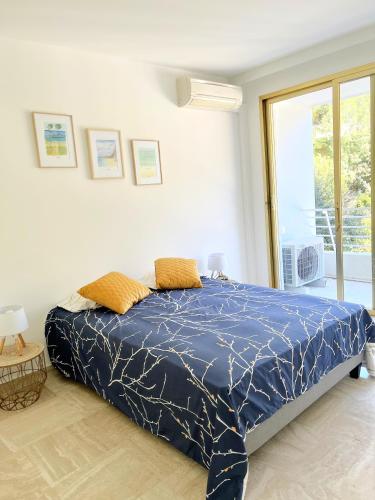 une chambre avec un lit avec une couette bleue dans l'établissement Solezia appartement, piscine et vue mer, by Welcome to Cannes, à Cannes