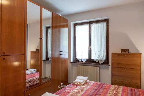 ein Schlafzimmer mit einem Bett, einer Kommode und einem Fenster in der Unterkunft Letizia Lake House - Lovere in Lovere