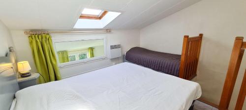a small bedroom with a bed and a window at Appartement dans résidence avec piscine in La Couarde-sur-Mer