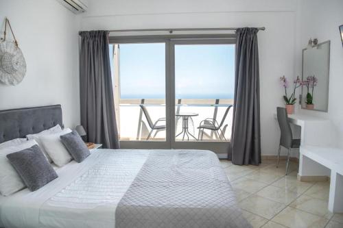 - une chambre avec un lit et une vue sur l'océan dans l'établissement AK Suites, à Imerovigli