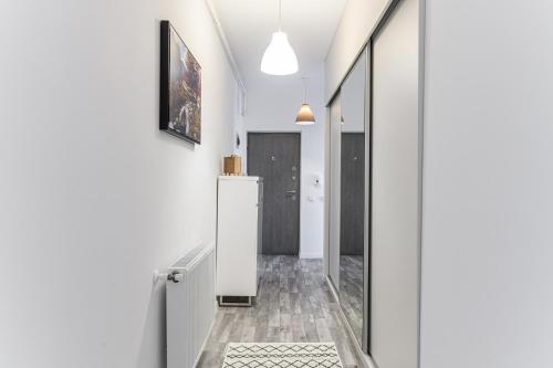a hallway of a house with white walls and a mirror at MaBu Apartment -2 camere spatios cu parcare subterana, Tractorul Brasov in Braşov