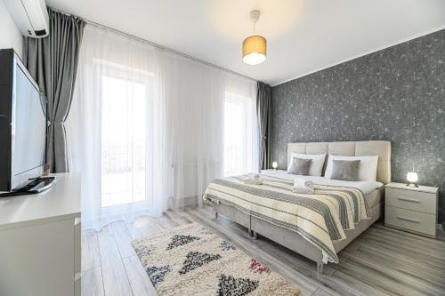 a bedroom with a bed and a television in it at MaBu Apartment -2 camere spatios cu parcare subterana, Tractorul Brasov in Braşov