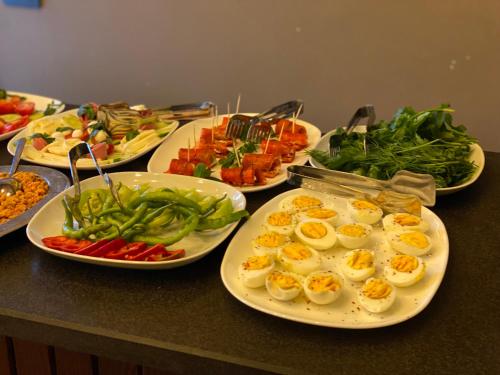 a table topped with plates of food with eggs and vegetables at Four Mansions Hotel in Kayseri