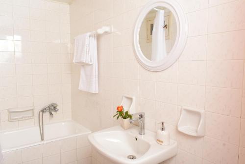 Baño blanco con lavabo y espejo en Artemida Pansion, en Kournás