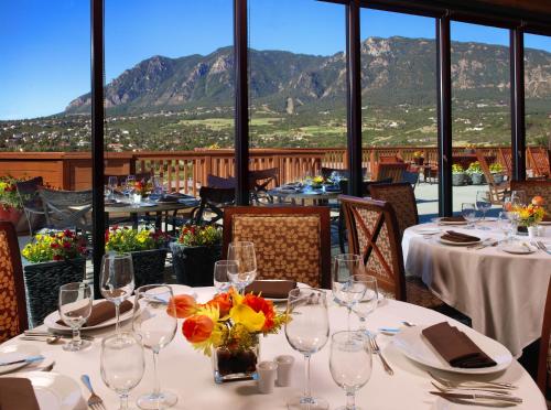 una sala da pranzo con tavoli e sedie con montagne sullo sfondo di Cheyenne Mountain Resort, a Destination by Hyatt Hotels a Colorado Springs