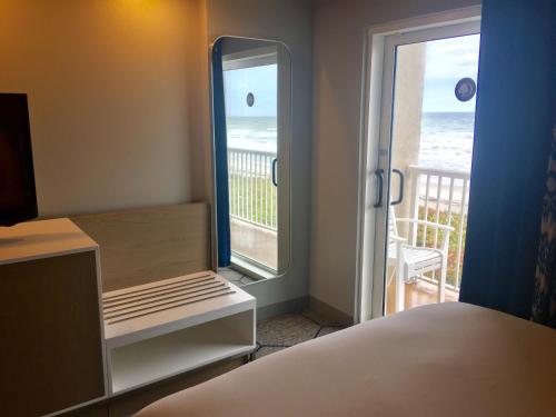 a bedroom with a bed and a view of the ocean at DoubleTree Suites by Hilton Melbourne Beach Oceanfront in Melbourne