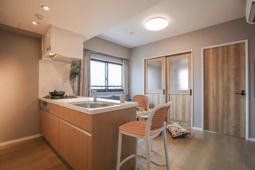 东京One-asakusa的带水槽和带椅子的柜台的厨房