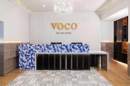 a lobby with a voco sign on the wall at voco Royalty Puebla Downtown in Puebla