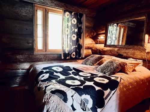 una camera da letto con un letto a forma di mucca in una baita di tronchi di Ruka View at the Slopes Ski in, Family & Bike Park, National Park, hike trails - Lapland Villas a Ruka