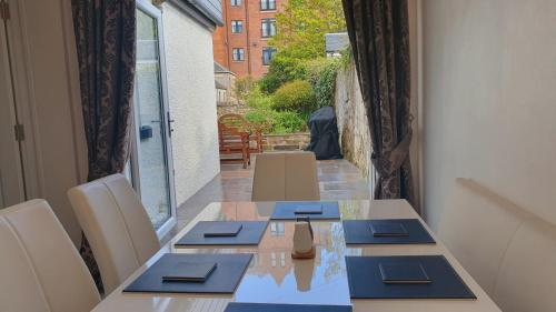 a dining room with a table and chairs and a window at Dunperrogh in St. Andrews