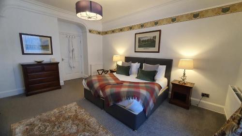 a bedroom with a bed and a table and a lamp at Dunperrogh in St. Andrews