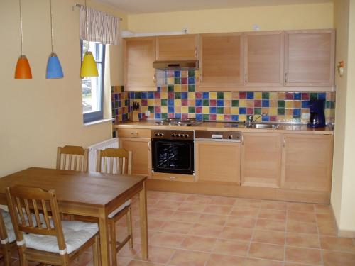 a kitchen with wooden cabinets and a table with chairs at Ferien unterm Reet in Prerow