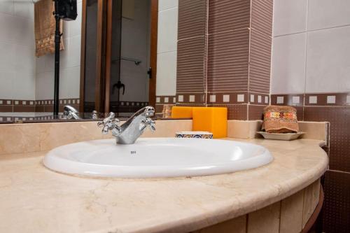 La salle de bains est pourvue d'un lavabo et d'un miroir. dans l'établissement Spacious BeachView Condo Marina - Families Only, à Agadir