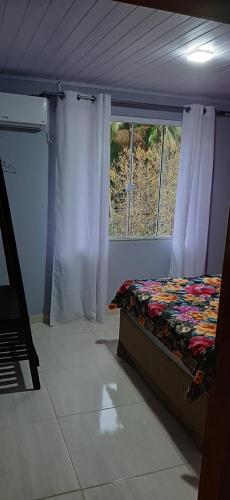 a bedroom with a bed and a window at Sitio Hoffmann in Pomerode
