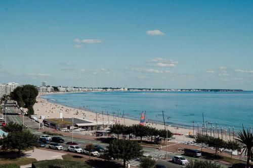 une vue d'une plage avec des gens et l'océan dans l'établissement Appart T3 standing 4ème étage La Baule Casino 7 pers, à La Baule