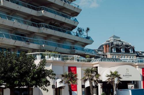 un bâtiment avec des palmiers devant dans l'établissement Appart T3 standing 4ème étage La Baule Casino 7 pers, à La Baule
