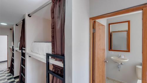Zimmer mit einem Etagenbett und einem Waschbecken sowie einem Badezimmer. in der Unterkunft DORADO PLAZA GETSEMANI in Cartagena de Indias