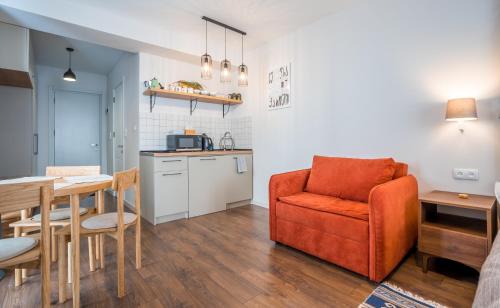 a kitchen and a living room with a couch and a table at New Gudauri Twins Apartment in Gudauri