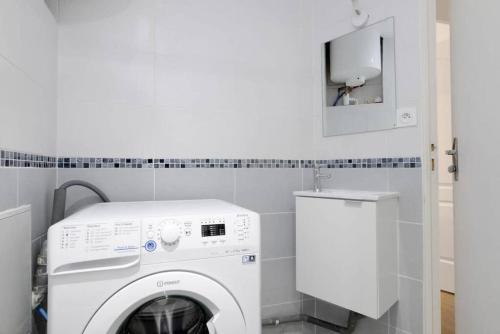 uma máquina de lavar e secar roupa branca numa pequena casa de banho em Studio Wifi Métro Paris (Résidence Péri) em Le Pré-Saint-Gervais