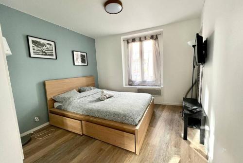 um quarto com uma cama e uma janela em Studio Wifi Métro Paris (Résidence Péri) em Le Pré-Saint-Gervais